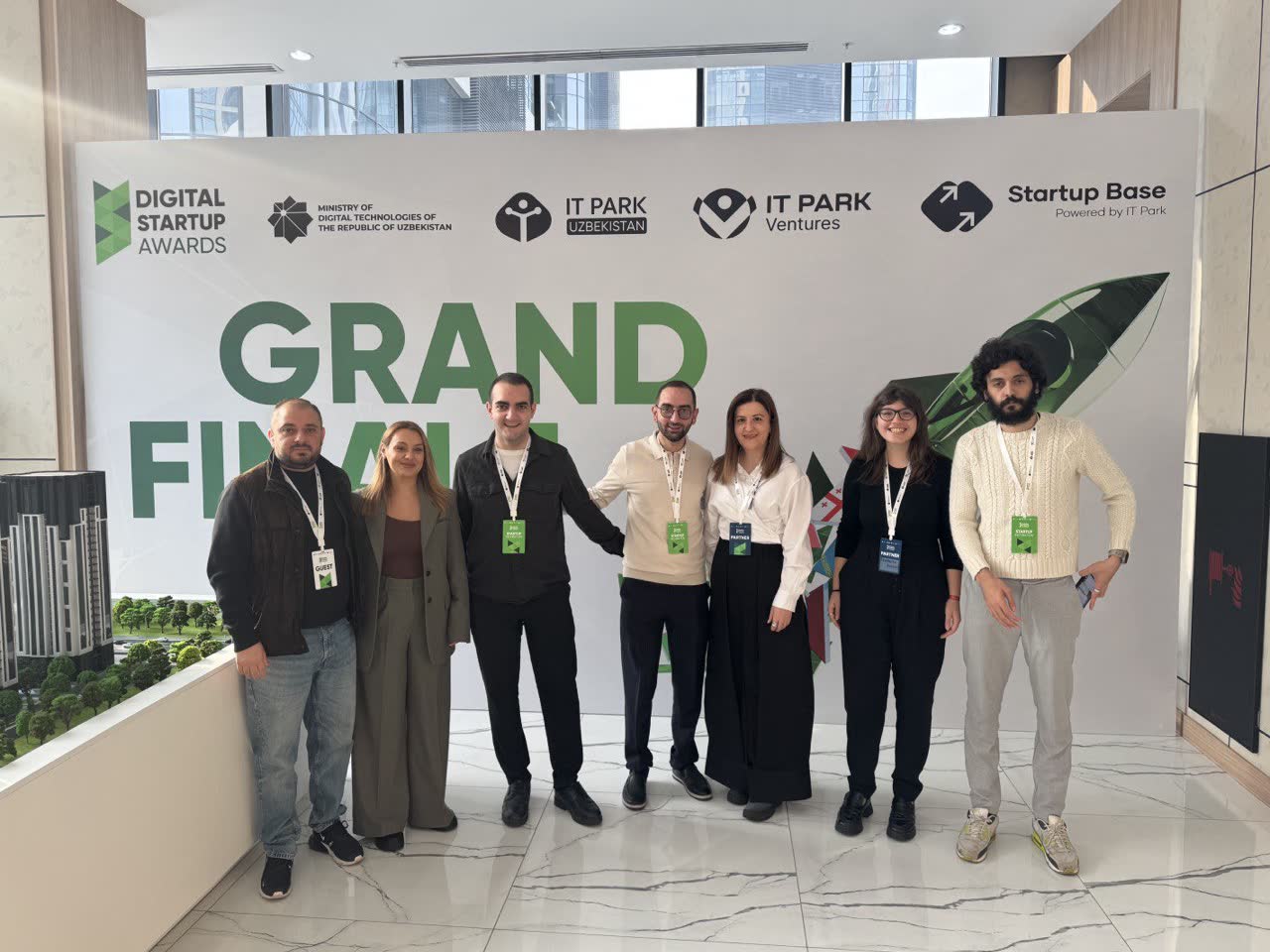 Seven people standing in front of a Digital Startup Awards Grand Finale backdrop carrying the logos of IT Park Uzbekistan and the Ministry of Digital Technologies